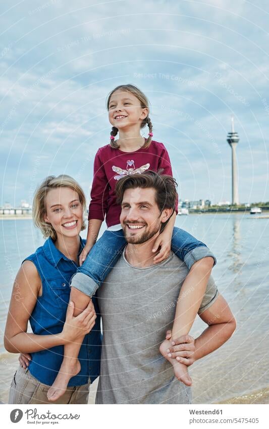 Germany, Duesseldorf, happy family with daughter at Rhine riverbank families riverside Affection Affectionate daughters River Rivers happiness people persons