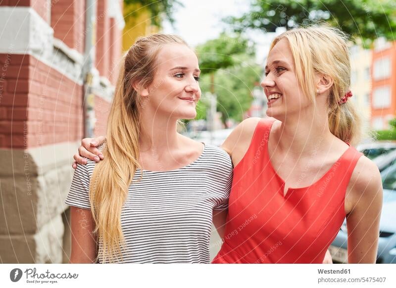 Two happy young women in the city together happiness female friends woman females town cities towns mate friendship Adults grown-ups grownups adult people