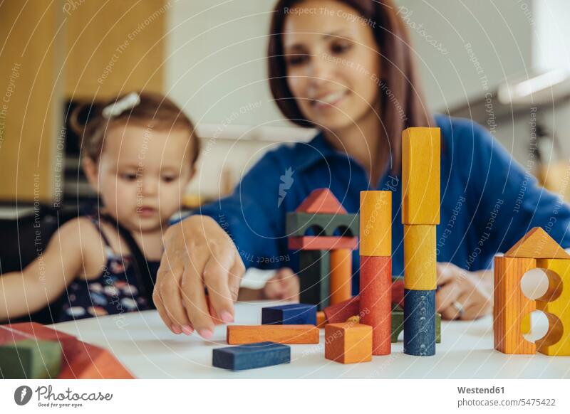 Happy mother and baby daughter playing with building blocks happiness happy infants nurselings babies mommy mothers ma mummy mama daughters people persons