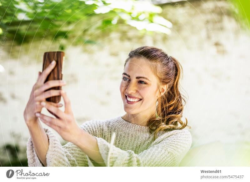 Portrait of relaxed woman taking selfie with cell phone Selfie Selfies portrait portraits Smartphone iPhone Smartphones females women relaxation mobile phone