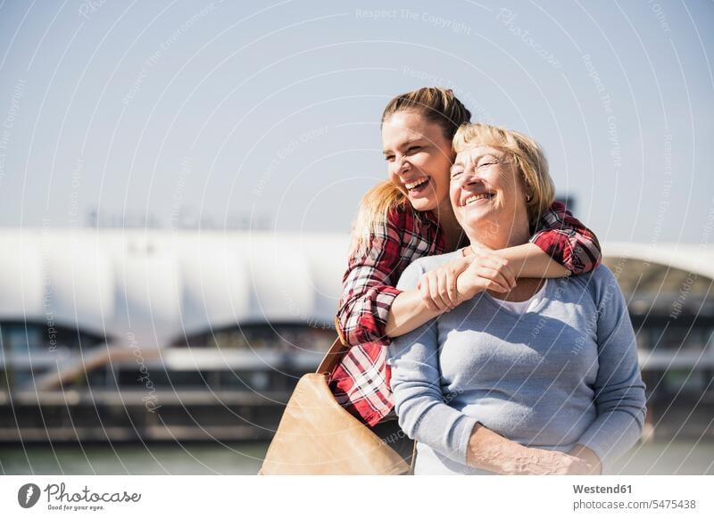 Young woman embracing her smiling grandmother sitting in wheelchair generation relax relaxing smile embrace Embracement hug hugging delight enjoyment Pleasant