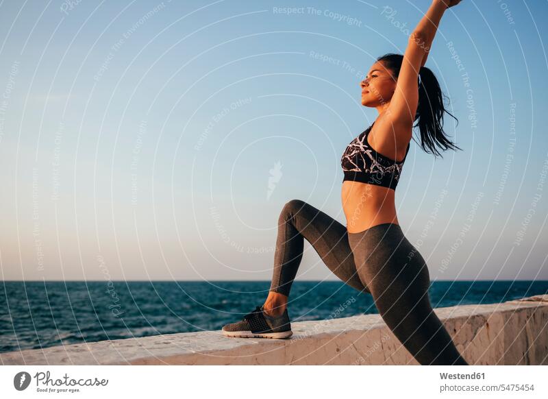 Female athlete practicing yoga at promenade during sunrise outdoors location shots outdoor shot outdoor shots color image colour image Self Improvement