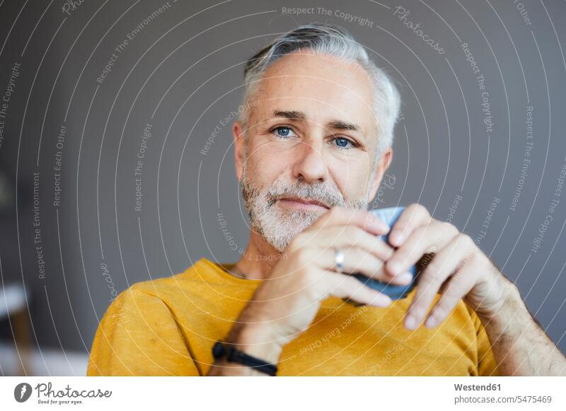 Portrait of relaxed mature man at home with cup of coffee human human being human beings humans person persons celibate celibates singles solitary people