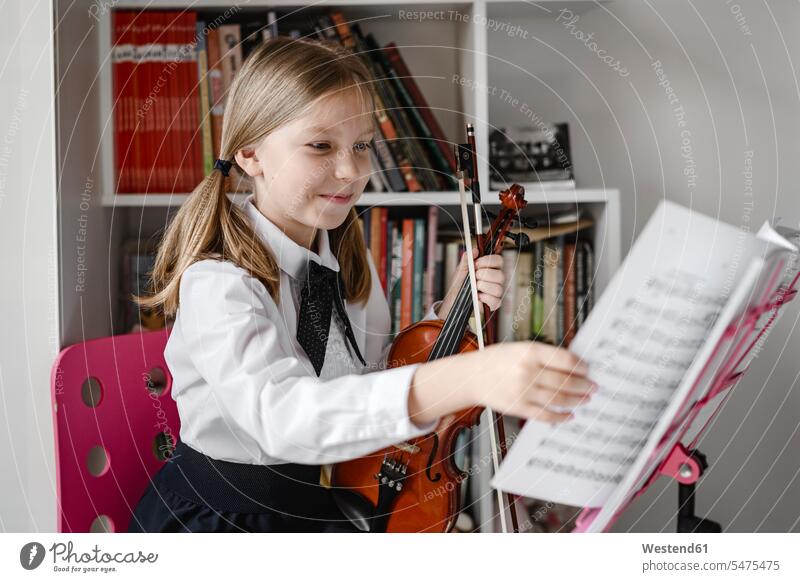 Smiling girl with violin looking at notes on the music stand violins music stands sheet music stand confidence confident making music playing music make music