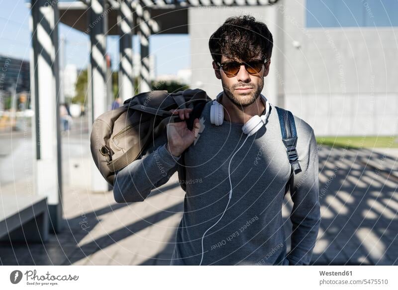 Cool man holding travelling bag in the city touristic tourists business life business world business person businesspeople Business man Business men Businessmen