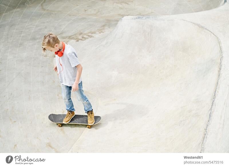 Boy with headphones on skateboard, skateboarding skateboarder skater skateboarders skaters Boarding Skate Board skateboards leisure free time leisure time boy