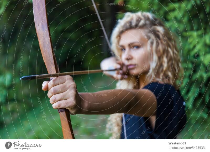 Archeress aiming with her bow, close-up arrow arrows archers female archer archeress Archery Bows bows archery shooting sports bowmen bowman close up closeups