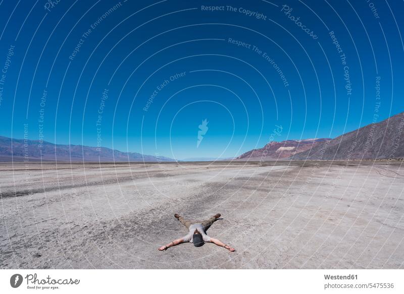 USA, California, Death Valley, man lying on ground in the desert laying down lie lying down men males Deserts Adults grown-ups grownups adult people persons