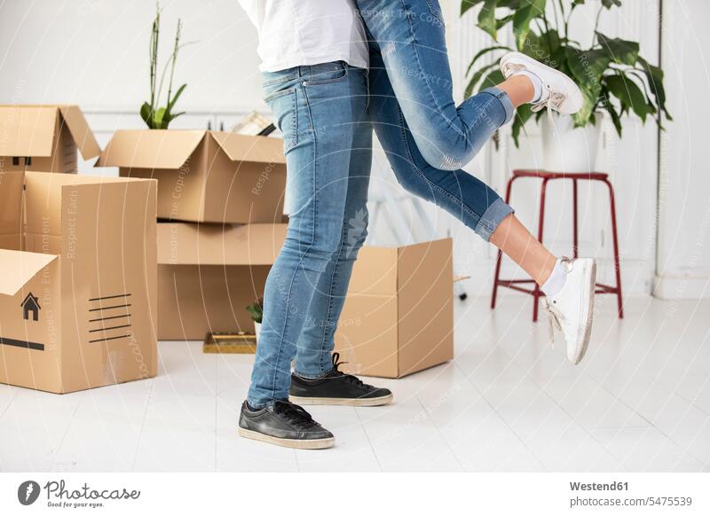 Close-up of happy ouple with cardboard boxes hugging in new home Cardboard Carton carton Cardboards cartons apartment flats apartments at home happiness couple