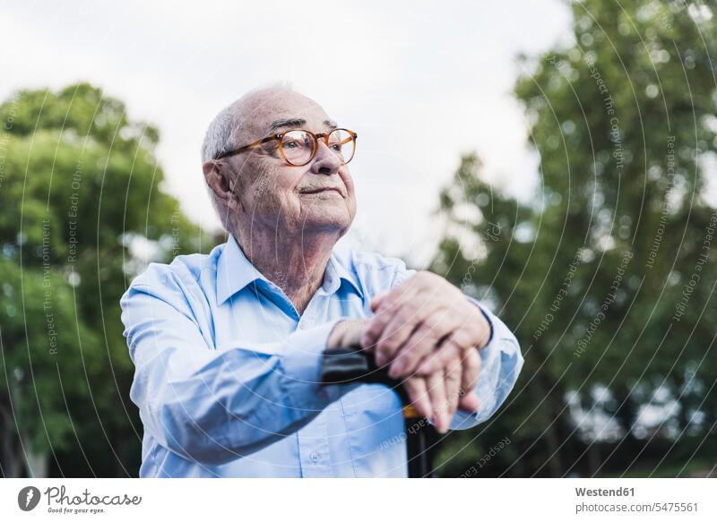 Portrait of senior man in a park leaning on his walking stick human human being human beings humans person persons caucasian appearance caucasian ethnicity