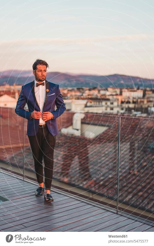 Italy, Florence, Portrait of stylish man on roof terrace at sunset suit coat suit jacket smart smart casual smart-casual Business Casual well dressed cultivated