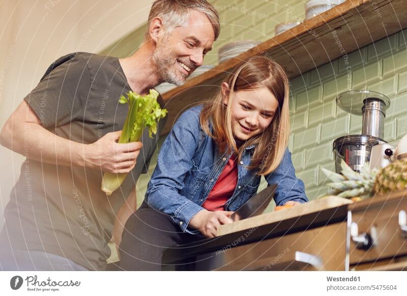 Happy father and daughter in kitchen preparing vegetables cut delight enjoyment Pleasant pleasure Cheerfulness exhilaration gaiety gay glad Joyous merry happy