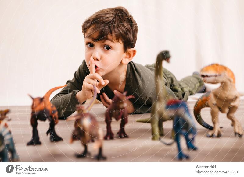 Portrait of little boy playing with toy dinosaurs plastic toys free time leisure time Humor Humorous Diverse diversification diversity varied funny having fun