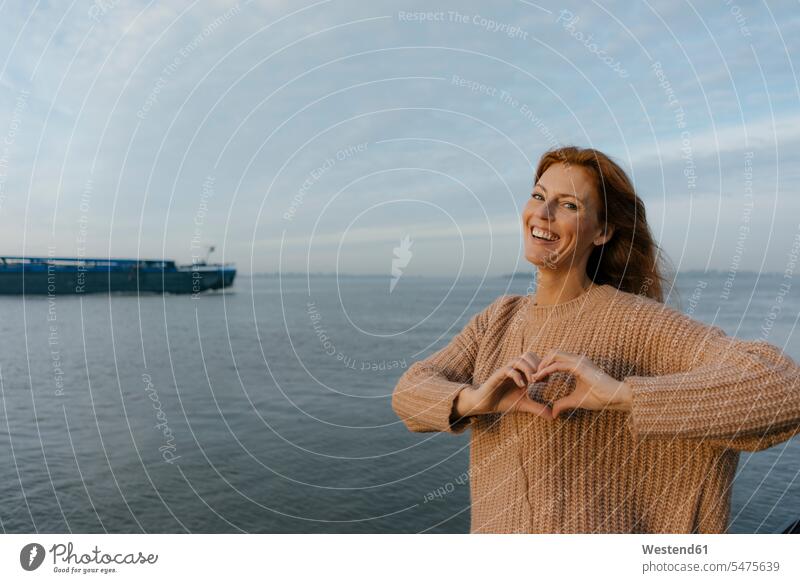 Germany, Hamburg, happy woman at the Elbe shore happiness females women ship smiling smile riverside riverbank Adults grown-ups grownups adult people persons