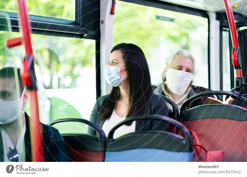 Woman wearing protective mask sitting in bus looking out of window, Spain transport motor vehicles road vehicle road vehicles buses busses travel traveling