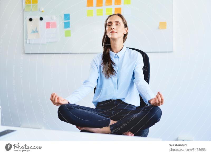 Young businesswoman sitting on office chair meditating Occupation Work job jobs profession professional occupation business life business world business person