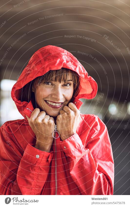 Woman wearing red rain coat, portrait portraits carefree laughing Laughter smiling smile rainjacket cagoule rain jacket beautiful Woman beautiful Women positive