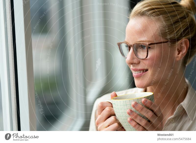 Young businesswoman with cup of coffee looking out of window Occupation Work job jobs profession professional occupation business life business world