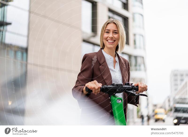 Portrait of happy young businesswoman with e-scooter in the city business life business world business person businesspeople business woman business women