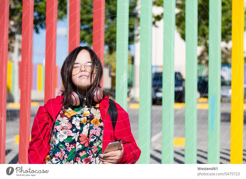 Teenager with down syndrome using smartphone, headphones, closed eyes hearing Down syndrome Down's Syndrome portrait portraits Teenage Girls female teenagers