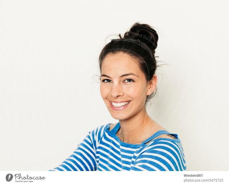 Beautiful young woman with black hair and blue white striped sweater is posing in front of white background caucasian caucasian ethnicity caucasian appearance