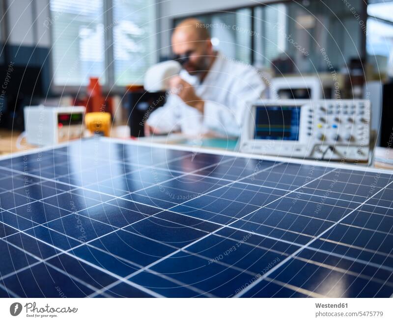 Solar panel and technician with microscope in background human human being human beings humans person persons caucasian appearance caucasian ethnicity european