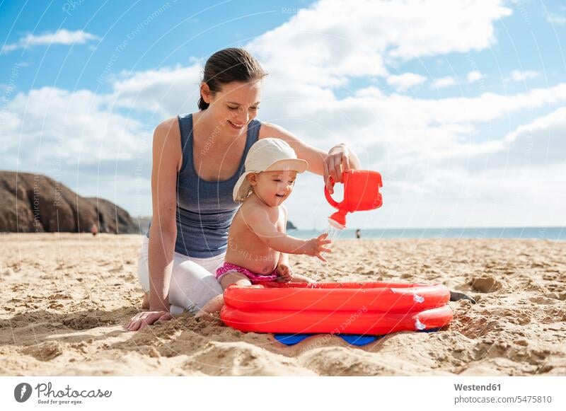 Mother playing with little daughter on the beach baby infants nurselings babies beaches mother mommy mothers ma mummy mama daughters people persons human being
