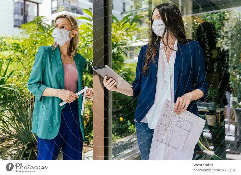 Two real estate agents wearing face masks while inspection outdoor area of house Occupation Work job jobs profession professional occupation business life