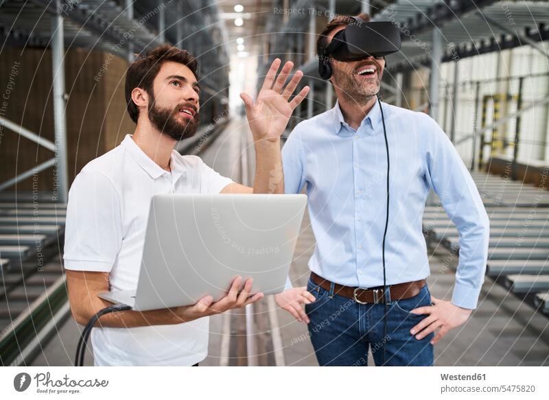 Man with laptop and businessman wearing VR glasses in factory colleague Occupation Work job jobs profession professional occupation business life business world