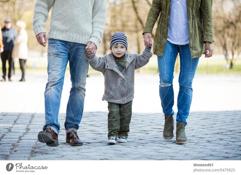 Portrait of boy walking hand in hand with parents boys males going son sons manchild manchildren portrait portraits kid kids people persons human being humans