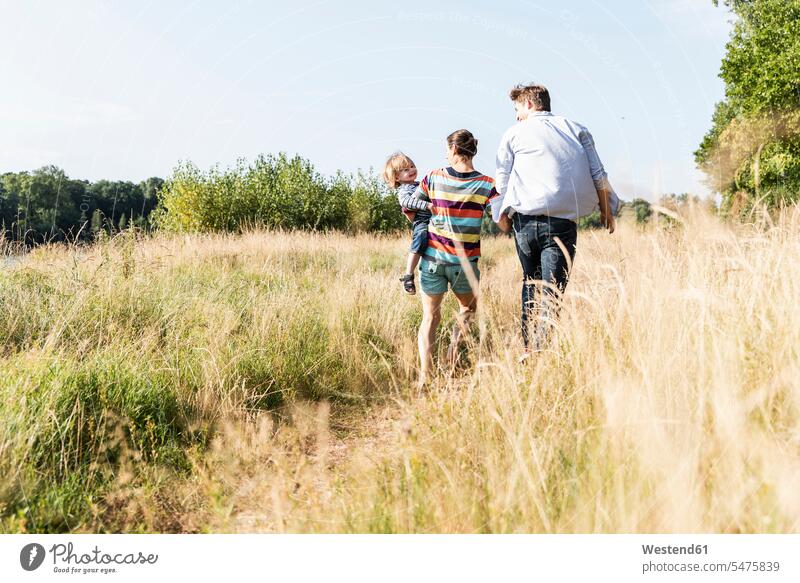 Happy family walking at the riverside on a beautiful summer day going Meadow Meadows happiness happy summer time summery summertime Plant Plants nature