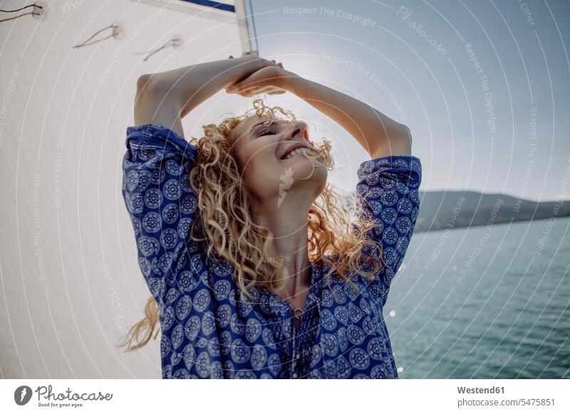 Carefree woman on a sailing boat in backlight sailboat Sail Boat Sailboats sailing boats carefree Backlit back light back lighting back lit females women vessel