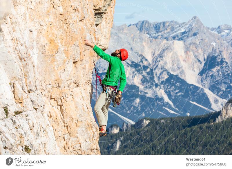 Italy, Cortina d'Ampezzo, man using chalk powder while climbing in the Dolomites mountains climber rock climber Sports Chalk Chalk Powder Magnesium rocks