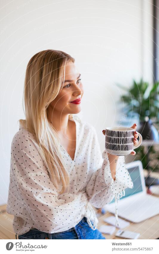 Young woman working in office, taking a break, drinking coffee Taking a Break resting Coffee businesswoman businesswomen business woman business women offices