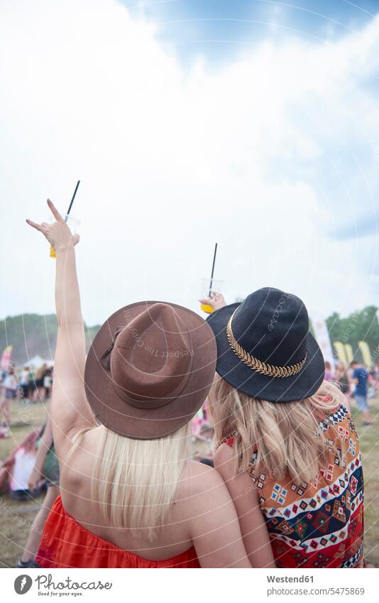 Friends cheering and holding plastic cups during music festival music festivals Festival Festivals Juice Juices female friends Fun having fun funny woman