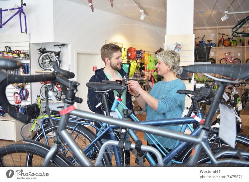 Salesperson helping customer in bicycle shop Bike shop bicycle store salesperson bicycle mechanic Bike Mechanic female customer consultancy consulting