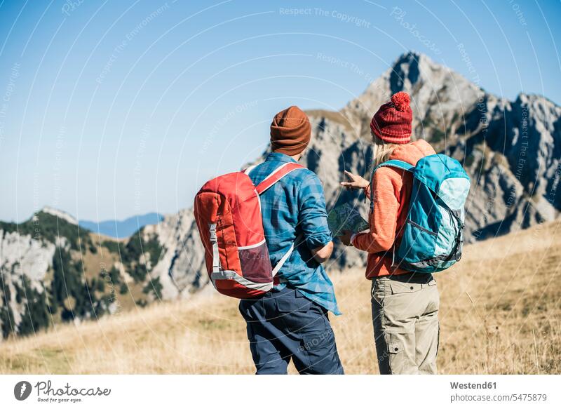 Austria, Tyrol, couple with map hiking in the mountains twosomes partnership couples hike maps mountain range mountain ranges people persons human being humans