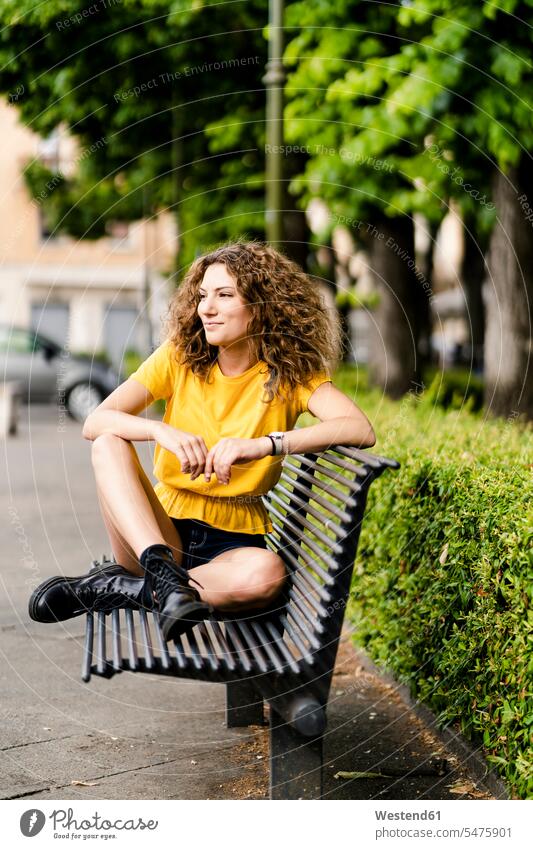 Smiling young woman sitting on a bench human human being human beings humans person persons caucasian appearance caucasian ethnicity european 1 one person only