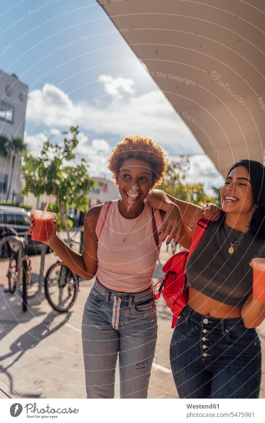 USA, Florida, Miami Beach, two happy female friends having a soft drink in the city town cities towns happiness refreshing drink soft drinks refreshing drinks