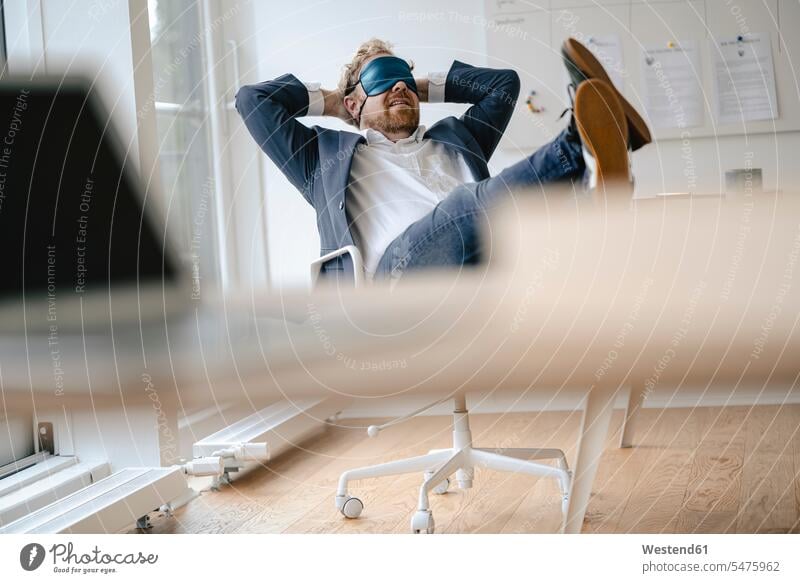 Businessman having a power nap at desk in office Occupation Work job jobs profession professional occupation business life business world business person