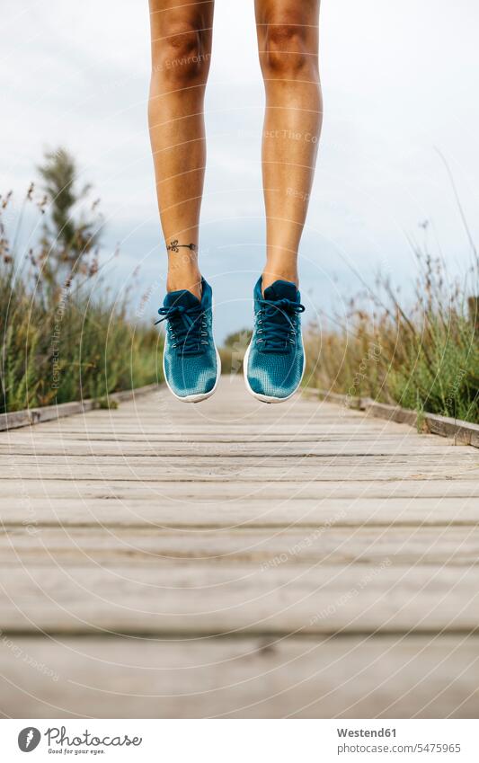 Feet of female jogger, jumping on a wooden walkway human human being human beings humans person persons caucasian appearance caucasian ethnicity european 1