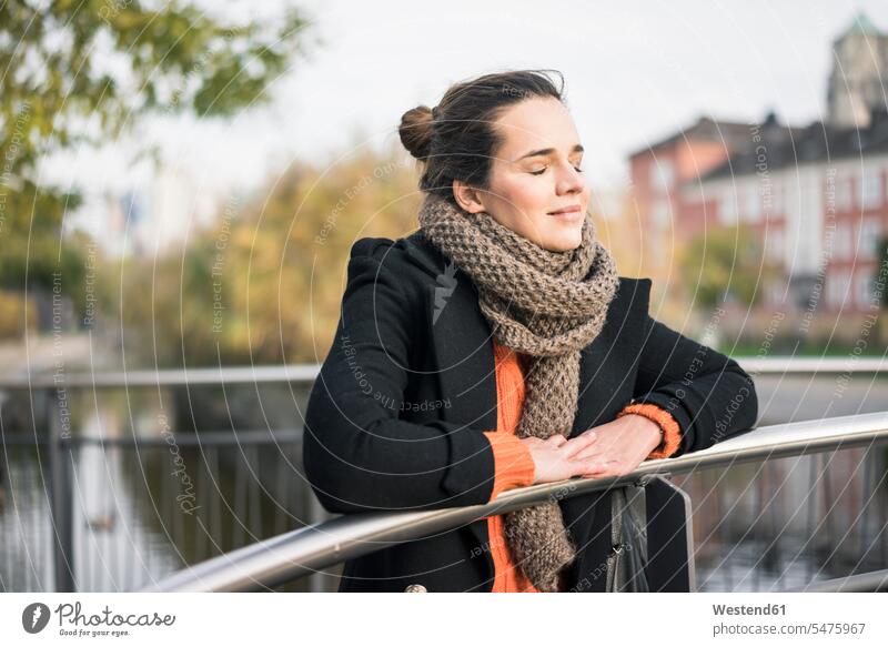 Portrait of woman in autumn leaning on railing relaxing females women portrait portraits Railing Railings rested on fall relaxation Adults grown-ups grownups
