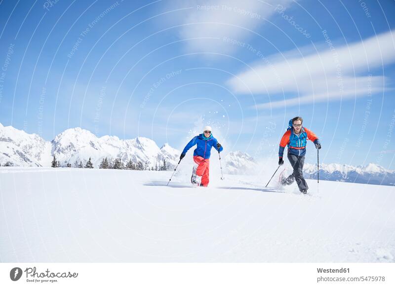 Austria, Tyrol, snowshoe hikers running through snow winter hibernal snowshoeing couple twosomes partnership couples winter sport Winter Sports wintersports