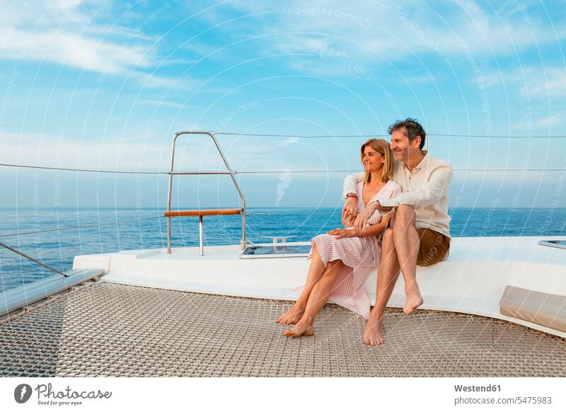 Mature couple enjoying quality time on sailing trip on a catamaran vacation Holidays twosomes partnership couples yachting sailing trips Quality Time Travel
