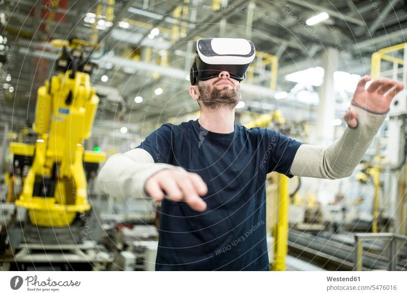Man wearing VR glasses in modern factory Occupation Work job jobs profession professional occupation blue collar blue collar worker blue-collar worker workers