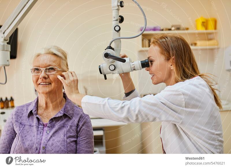 ENT physician examining ear of a senior woman ears senior women elder women elder woman old Female Doctor physicians Female Doctors checking examine people