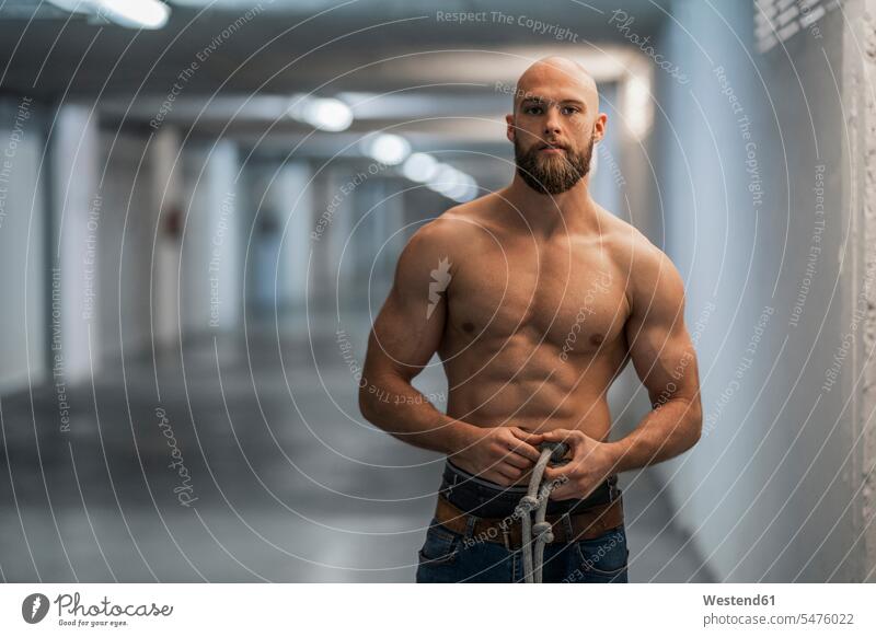 Portrait of a barechested athlete with rope human human being human beings humans person persons bald head baldy Completely Bald pants Trouser Denim Jeans ropes