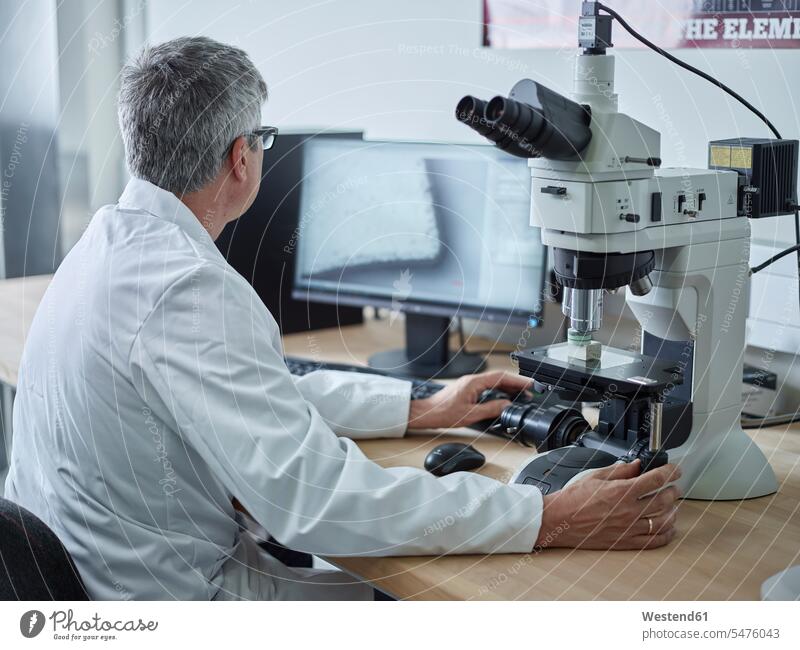 Physician working with microscope, looking on screen laboratory microscopes examining checking examine laboratory technician Lab Tech workplace work place