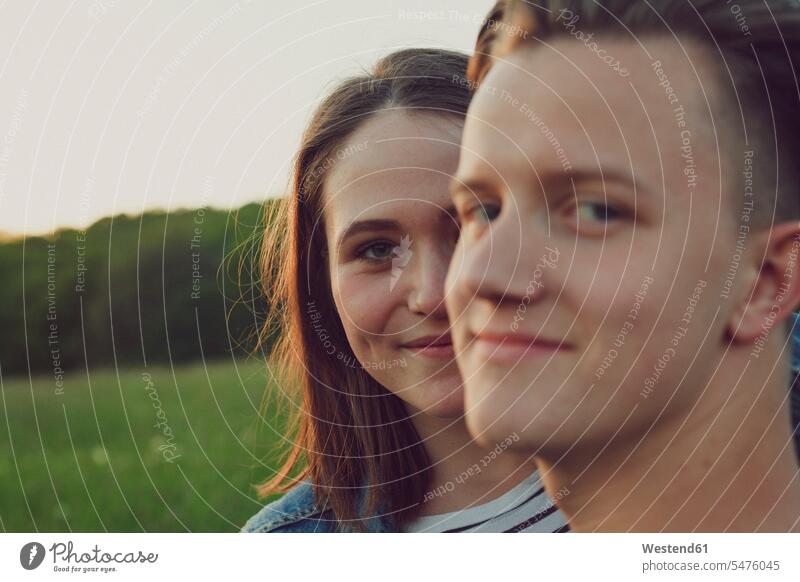 Portrait of happy teenage girl hiding behind her boyfriend hide portrait portraits happiness Hide optimistic optimism caucasian caucasian ethnicity