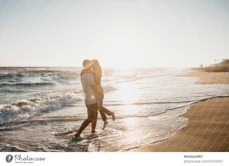 Affectionate young couple hugging at the seashore at sunset human human being human beings humans person persons caucasian appearance caucasian ethnicity